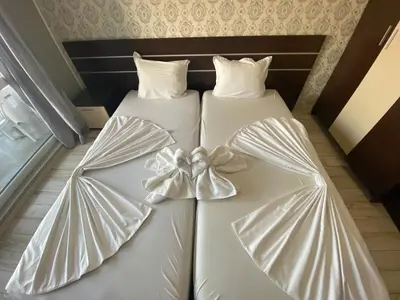 two beds with white gowns with bows on them at PARADISO B 209 Private Sea View Studio NESSEBAR in Nesebar