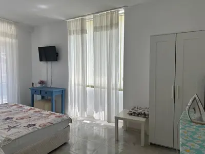 a bedroom with a bed and a blue table and window at Oazis Ravda in Ravda