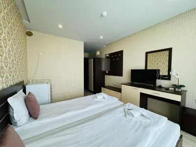 a bedroom with a white bed and a television at PARADISO B 208 Private Sea View Studio NESSEBAR in Nesebar