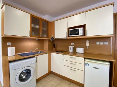 a kitchen with a washing machine and a microwave at ANITA A 25 Apartment Pool View SUNNY BEACH in Sunny Beach