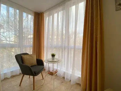 a chair and a table in front of a window at ANITA A 25 Apartment Pool View SUNNY BEACH in Sunny Beach