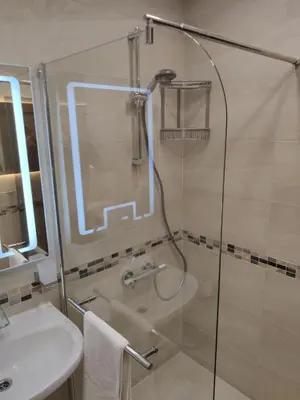 a shower with a glass door next to a sink at Sun Coast Apartment in Sveti Vlas