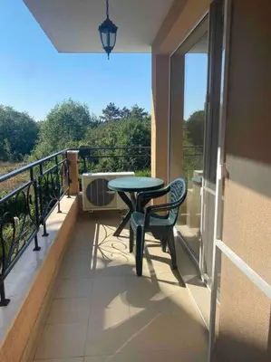 a balcony with a table and chair on a balcony at Pomorie residence 2-bedroom apartment 300m to the beach in Pomorie