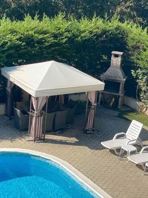 a white umbrella and chairs next to a swimming pool at Pomorie residence 2-bedroom apartment 300m to the beach in Pomorie