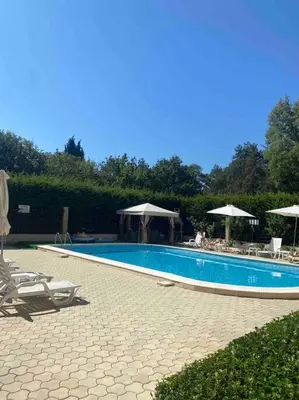 a large swimming pool with chairs and umbrellas at Pomorie residence 2-bedroom apartment 300m to the beach in Pomorie