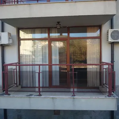 a balcony with a red railing in front of a window at Helios 350m from the beach in Sveti Vlas