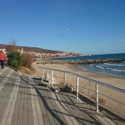 a person walking on a sidewalk near the beach at Helios 350m from the beach in Sveti Vlas