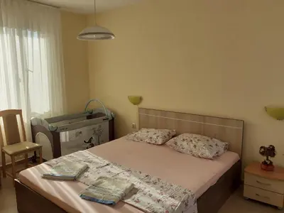 a bedroom with a bed and a chair at Apartments Sea Sounds in Pomorie