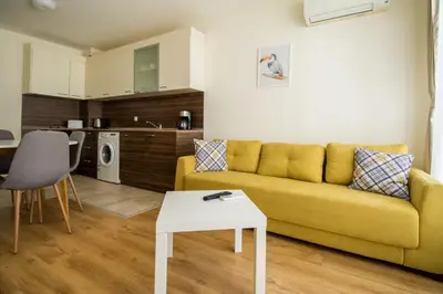 a living room with a yellow couch and a table at White Cliffs, Byala in Byala