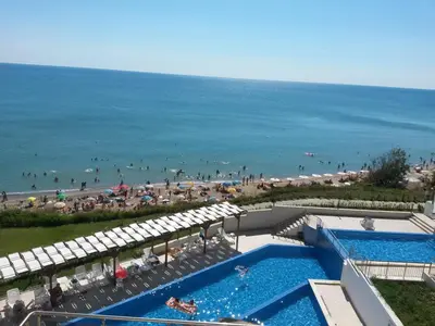 an aerial view of a beach with a swimming pool and umbrellas at White Cliffs, Byala in Byala
