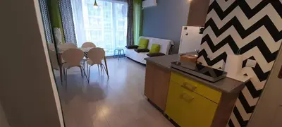 a kitchen and living room with a table and chairs at Spokojne wakacje w Bułgarii in Sunny Beach