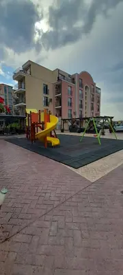 a playground in front of a building with buildings at Spokojne wakacje w Bułgarii in Sunny Beach
