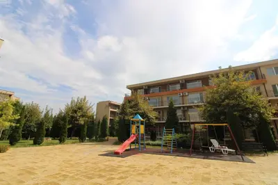 a playground in front of a building with a slide at Holiday-Orchid Menada Apartments in Sunny Beach