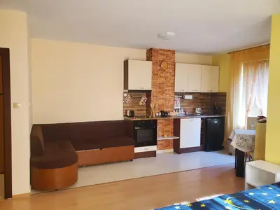 a living room with a couch and a kitchen at Уютно и просторно студио in Ravda