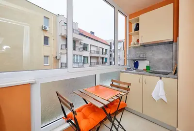 a balcony with a table and chairs and a kitchen at Студио Патрисия in Pomorie