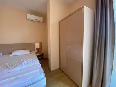 a small bedroom with a bed and a cabinet at MESSEMBRIA B504 Studio Sunny Beach in Sunny Beach