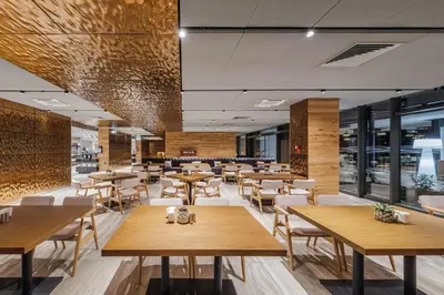a restaurant with wooden tables and chairs at Voya Beach Resort - Ultra All Inclusive in Sveti Vlas