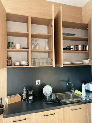 a kitchen with wooden cabinets and a sink and a counter at City view in Residences in Burgas City
