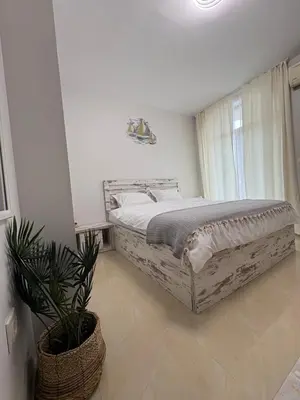 a bedroom with a large bed and a potted plant at Къмпинг градина луксозен апартамент in Chernomorets