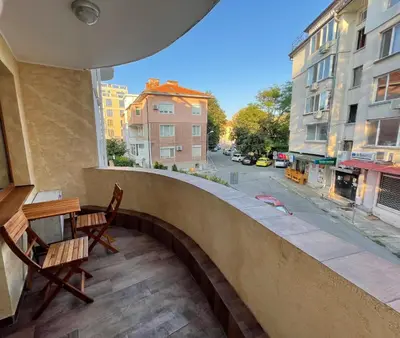 a balcony with chairs and a table and a street at Apartament deluxe Karina-Free parking in Burgas City