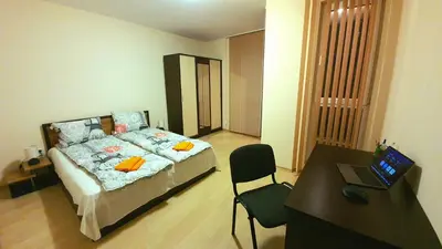 a bedroom with a bed and a desk with a laptop at Minimalistic 1BR flat with a Parking spot in Varna City