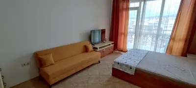 a living room with a couch and a television at Central Plaza - Studio - Sunny Beach in Sunny Beach