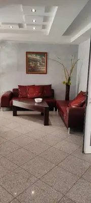 a living room with two red couches and a table at Central Plaza - Studio - Sunny Beach in Sunny Beach