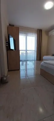 a bedroom with a bed and a flat screen tv at Sea Dreams Apartment in Sveti Vlas