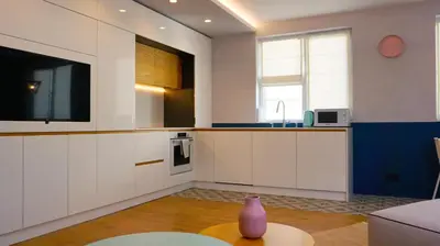 a kitchen with white cabinets and a vase on a table at Апартамент Жасмин с частен гараж - Jasmin Apartment with private garage in Varna City