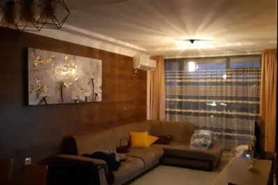 a living room with a couch and a window at Апартамент Адикт in Sozopol