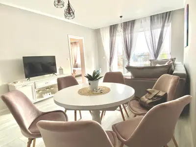 a living room with a table and chairs at Apartments in complex PANORAMA in Chernomorets