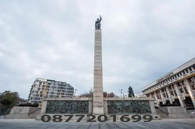 a monument in a square in front of two buildings at Best Price - Downtown Flat in Burgas City