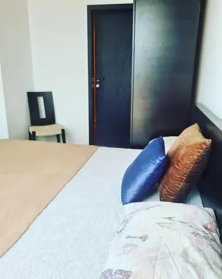 a bedroom with a bed with blue pillows on it at Atlantis Resort Sea View in Burgas City
