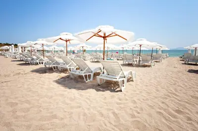 a row of chairs and umbrellas on a beach at Atlantis Resort Sea View in Burgas City