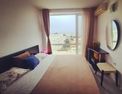 a bedroom with a bed and a large window at Atlantis Resort Sea View in Burgas City