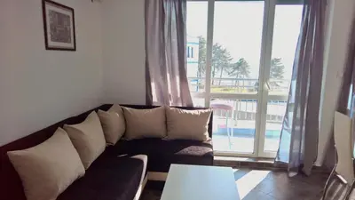 a living room with a couch and a large window at Private apartment with sea view in Blue Bay Pallace in Pomorie