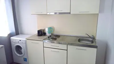 a small kitchen with a sink and a washing machine at Private apartment with sea view in Blue Bay Pallace in Pomorie