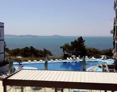 a large swimming pool with a view of the ocean at Private apartment with sea view in Blue Bay Pallace in Pomorie