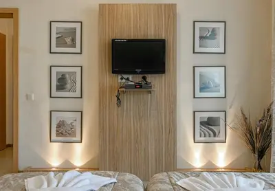 a room with a tv on a wall with pictures at Александра in Sveti Vlas