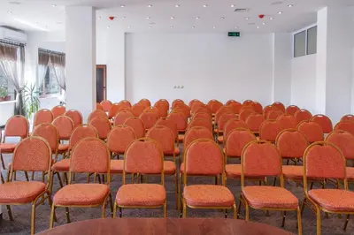 an empty room with rows of orange chairs at Александра in Sveti Vlas
