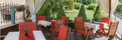 a restaurant with red chairs and tables on a patio at Александра in Sveti Vlas