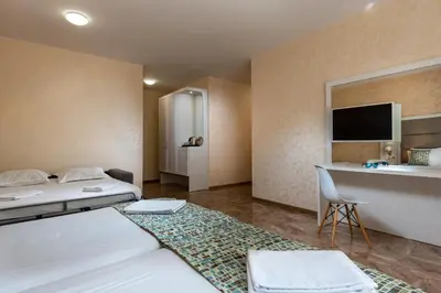 a hotel room with two beds and a desk at Marina Sands Bijou Boutique - Amazing views in Obzor