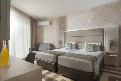 a hotel room with two beds and a desk at Marina Sands Bijou Boutique - Amazing views in Obzor