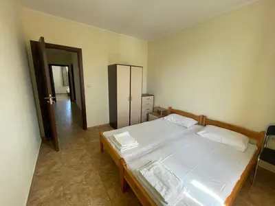 a bedroom with a large bed with white sheets at private apartments in Apolon in Ravda