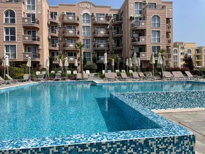 a swimming pool in front of a building at Marea Garden apartments in Ravda