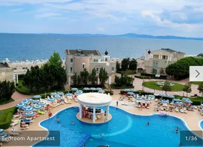 a resort with a pool with umbrellas and a beach at 