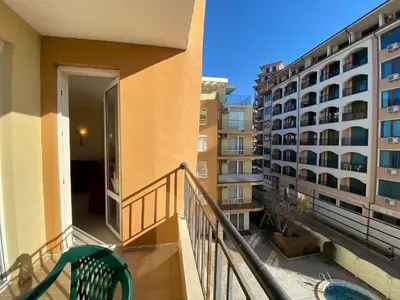 a balcony of a apartment building with a green chair at BLUE MARINE C16 Apartment Sunny Beach in Sunny Beach