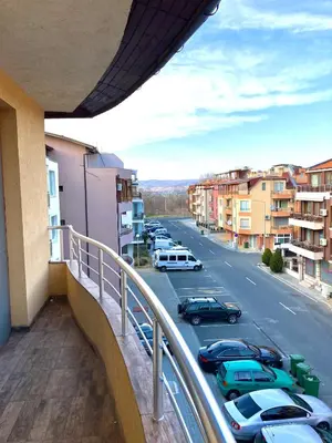 a balcony with a view of a parking lot with cars at Dune Apartment Nessebar in Nesebar