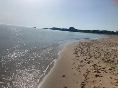 a beach with footprints in the sand and water at Вила Елия - почивка край морето in Lozenets