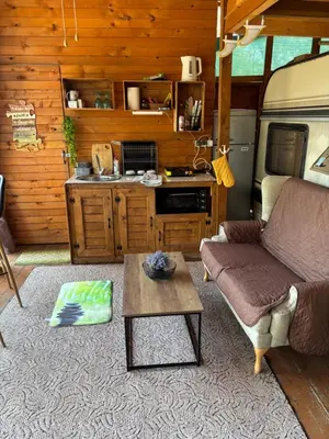 a living room with a couch and a kitchen in an rv at Вила Елия - почивка край морето in Lozenets